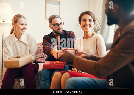 Portrait von eleganten erwachsenen Menschen den Austausch von Geschenken während der Weihnachtsfeier zu Hause, Kopie Raum Stockfoto
