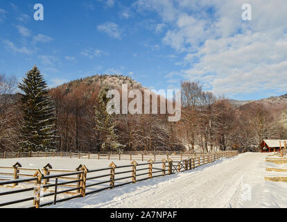 Malerische schneebedeckten Land und Berge im Romania-Malini im Winter. Winter schneebedeckte Landstraße unter einem blauen Himmel in einem Bergdorf. W Stockfoto