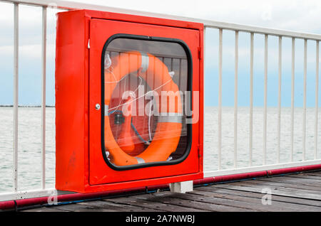 Leben Boje im Schaufenster hängen auf einem Ponton Brücke Geländer an der Küste. Tools für die Menschen retten, für den Notfall. Stockfoto