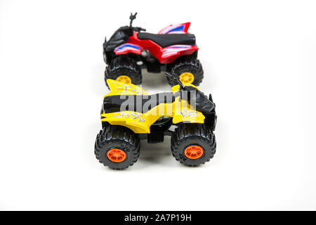 Rote und gelbe Spielzeug Plastic Quad ATV auf weißem Hintergrund Stockfoto