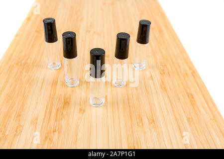 Mehrere Durchstechflaschen aus Glas mit schwarzen Tops auf einem Holz Hintergrund isoliert Stockfoto