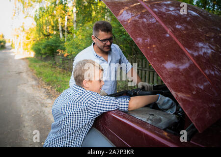 Vater Lehre, sein Sohn, wie das Öl auf der Familie Auto zu prüfen. Stockfoto