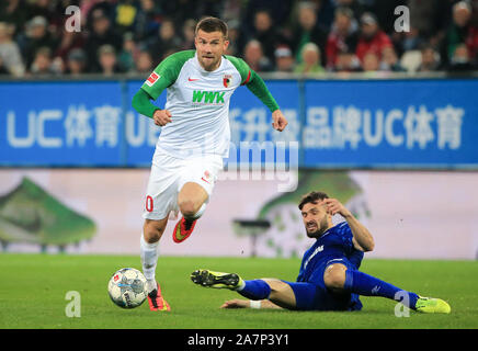 Augsburg, Deutschland. 3. November, 2019. Daniel Baier (L) von Augsburg bricht durch die Verteidigung von Daniel Caligiuri von Schalke 04 während einer Deutschen Bundesligaspiel zwischen dem FC Augsburg und der FC Schalke 04 in Augsburg, Deutschland, an November 3, 2019. Credit: Philippe Ruiz/Xinhua/Alamy leben Nachrichten Stockfoto