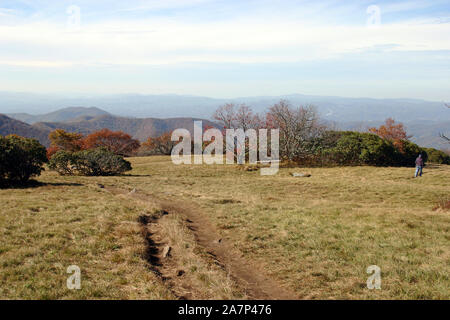 Ein entfernter älterer Mann Wanderungen eine Wicklung Schmutz weg hin zu einem Scenic Mountain Vista an einem Herbsttag in den Bergen des westlichen North Carolina Stockfoto