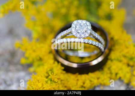 Hochzeit und Verlobungsringe Nahaufnahme, Ringe auf gelbe Blume Stockfoto