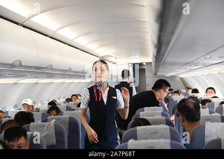 Ein Flight Attendant dient Passagiere in einem Flugzeug von China Express am Flughafen Chongqing Wushan, betitelt eine "In-der-Flughafen Wolken', in Chongq Stockfoto