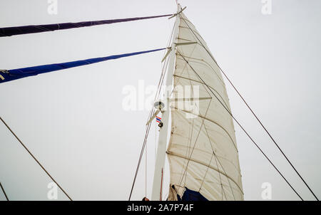 Von unten weiß gewellt Yacht segeln, grauen Himmel Segelfertige zu beruhigen Stockfoto