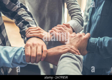 Startupers arbeiten im Büro zusammen halten sich an den Händen der gegenseitig unterstützen Stockfoto