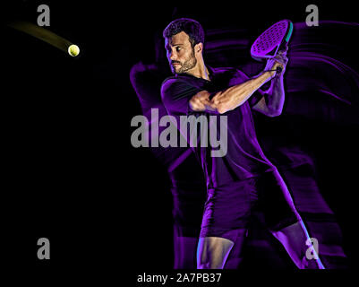 Eine kaukasische Paddle tennis player Mann studio Schuß auf schwarzen Hintergrund mit Licht malen blur Effekt isoliert Stockfoto