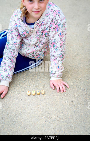 Dreidels für Chanukka. Jüdisches Kind das Spiel mit dem Dreidel outdoor. Chanukah. Die Buchstaben auf dem DREIDEL sind die ersten Buchstaben Hebräische Satz, bedeutet ein großes Wunder passiert hier. Stockfoto