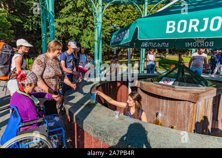 Borjomi, Georgien - 12. August 2019: Touristen Menschen trinken Borjomi Mineralwasser Samtskhe Javakheti region Georgien Osteuropa Stockfoto