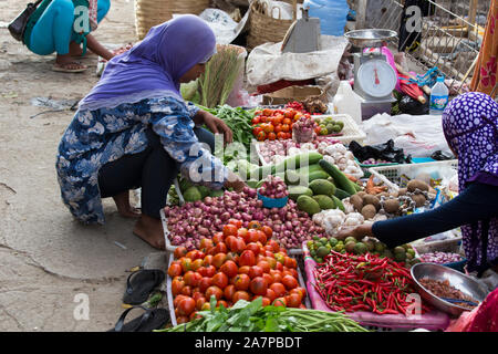 Labuanbajo, Indonesien - 17. August 2015: Eine Frau wird den Verkauf von Gemüse auf einem Straßenmarkt in Labuanbajo Stockfoto