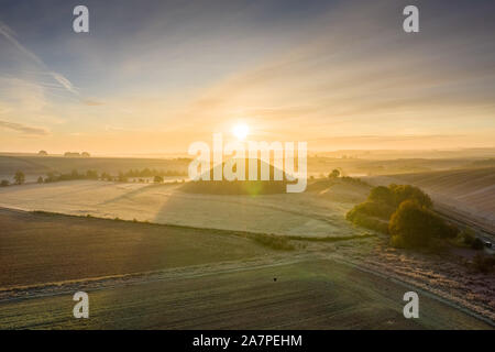 Silbury Hill, Nr Avebury, Wiltshire, UK. 28. Oktober 2019. Drone Bild von einem frostigen Roten morgen Himmel über dem alten künstlichen Erdhügel Silbury Hill. Stockfoto