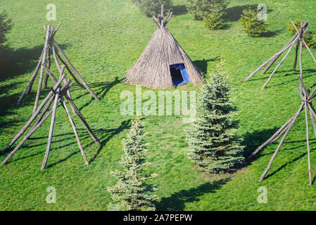 Erholung im Freien. Wahre Natur. Stroh Wigwam auf einer Lichtung an einem sonnigen Frühlingstag. Wigwam Typ strohgedeckten Hütten. Stockfoto