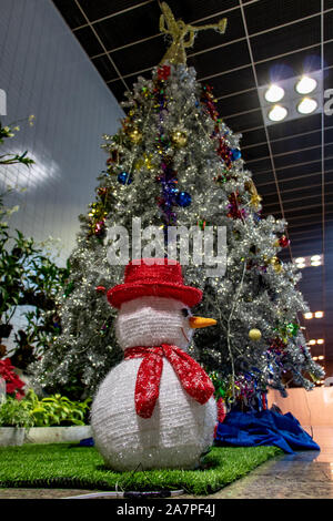 Schneemann und Weihnachtsbaum im Dezember innerhalb des Don Mueang International Airport, Bangkok, Thailand Stockfoto