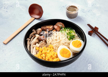 Ramen. Soba Nudeln mit gekochten Eiern, Champignons, und Gemüse, mit Willen, traditionellen hölzernen Löffel und Essstäbchen Stockfoto