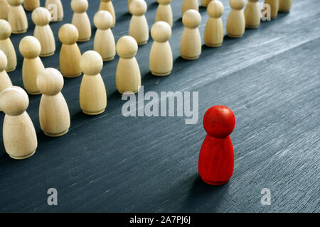 Führung Management Konzept. Rote Figur als Gegenteil von Holzfiguren. Stockfoto