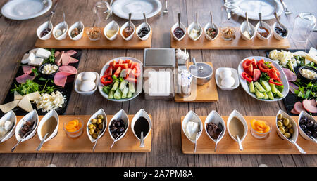 Vorbereitung auf ein reichhaltiges mediterranes Frühstück für eine Gruppe. Stockfoto