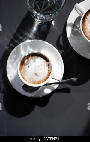 Frisch Gebrühter Cappuccino in Zwei Demitasse Cups. Overhead-Ansicht des Kaffees auf dem dunklen Hintergrund. Stockfoto