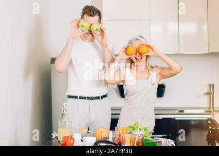 Romantische neu verheiratete Paare Kochen gesund essen und Spaß zusammen in der Küche zu Hause. Kaukasische Frau und Mann Vorbereitung Gemüsesalat Stockfoto