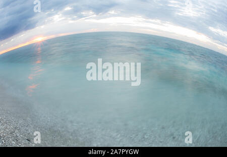 Unsere Blue Earth: Fisheye auf den Strand und den Sonnenaufgang über dem Pazifischen Ozean/Tasmanischen Meer auf Lady Elliot Island, Coral Island am Great Barrier Reef Stockfoto