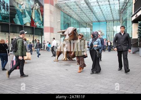 BIRMINGHAM, Großbritannien - 24 April 2013: Menschen gehen vorbei Stier Skulptur an der Stierkampfarena in Birmingham. Die berühmte Bronze Skulptur wurde von Laurence Brode erstellt Stockfoto