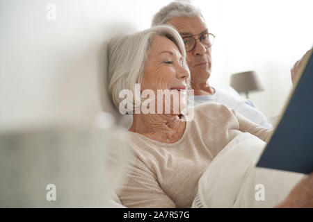 Senior paar Entspannen und Lesen im Bett Stockfoto