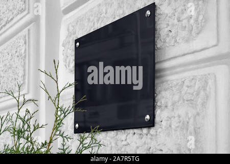 Blank schwarzes Glas Schild auf grau strukturierte Wand mockup Stockfoto