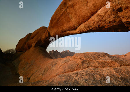 Die Brücke von der Felsformation an der Spitzkoppe mit Pondok Berge im Hintergrund. Usakos, Namibia, Afrika Stockfoto