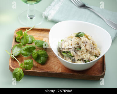 Spinat und Pilze risotto serviert in einer weißen Schüssel Stockfoto