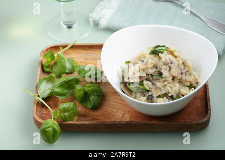 Spinat und Pilze risotto serviert in einer weißen Schüssel Stockfoto