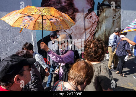 Berliner Mauer, Asiatische tourist Group, ein Mann mit Regenschirm Gustav Klimt an der East Side Gallery, Breschnew Honecker küssen Deutschland Stockfoto