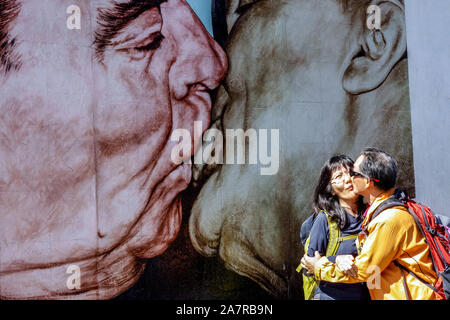 Berliner Mauer Graffiti, East Side Gallery Kuss, asiatische Touristen küssen unter einem furchterregenden Kuss, Breschnew, Honecker, Deutschland Graffiti Mauer Berlin Stockfoto