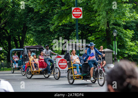 New York, USA - Juni 6, 2019: Passagiere in der Rückseite einer Fahrradrikscha schauen Sie heraus, wie Sie in der Nähe des Central Park. Stockfoto