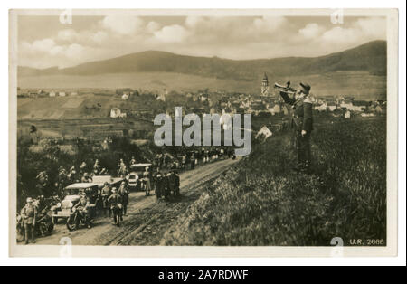 Deutsches historisches Foto: Wehrmachtssoldat Trompeten auf einem Hügel vor einer Armeesäule aus Autos und Motorrädern, militärische Übungen Stockfoto