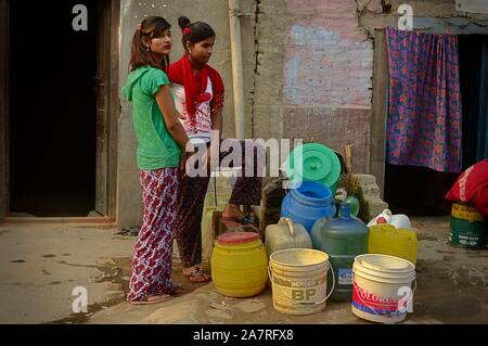 Frauen warten in Kathmandu während der Trockenzeit auf einen Wasserwagen, ein Jahr nach den Erdbeben in Nepal 2015. Stockfoto