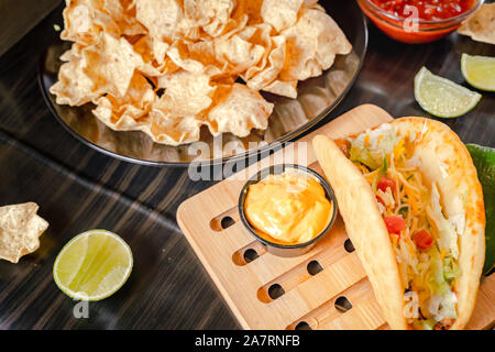 Hausgemachte Baja Fisch Tacos mit Mango Salsa und Chips. Gemischte mexikanisches Essen: Guacamole, Nachos, Fajita, Fleisch Tacos. Ansicht von oben. Tex-mex Küche. Stockfoto
