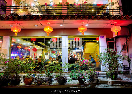 SHENZHEN, China - ca. April 2019: Ein Restaurant mit traditionellen roten Laternen in einer Straße in Shenzhen eingerichtet. Stockfoto