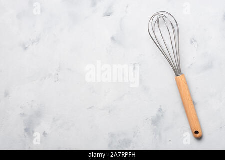 Schneebesen kochen Egg Beater mixer Whisker mit Holz auf Tisch Top view Griff Stockfoto