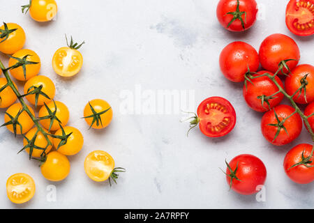 Tomaten Sortiment, frische rote auf Zweig reif, Rot und Gelb, ganz und halbiert, auf rustikalen Tisch Ansicht von oben. Stockfoto