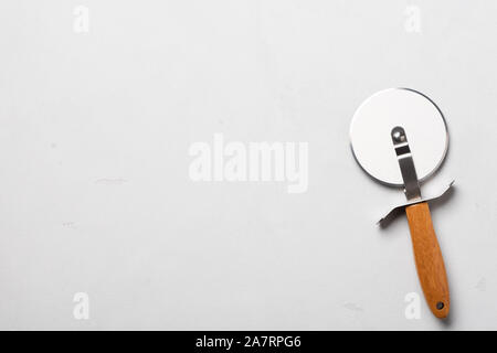 Sauber pizza Cutter mit Holz auf Stuck table top anzeigen Griff Stockfoto