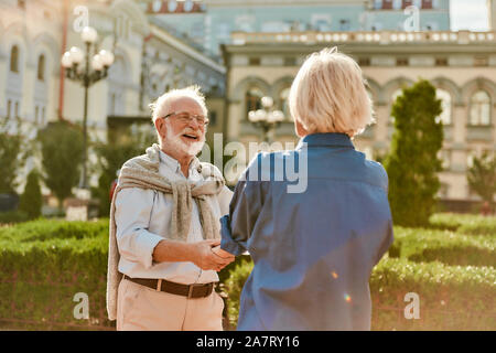 Die Zeit zusammen genießen. Schönes älteres Paar lächelnd und Tanz im Freien an einem sonnigen Tag. Spaß haben. Liebe Konzept. Glückliche Momente Stockfoto
