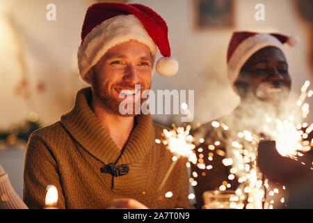 Portrait von fröhlichen bärtigen Mann mit Weihnachtsmütze und genießen Sie Weihnachten feiern mit Freunden und Familie Stockfoto