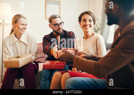 Portrait von eleganten erwachsenen Menschen den Austausch von Geschenken während der Weihnachtsfeier zu Hause, Kopie Raum Stockfoto
