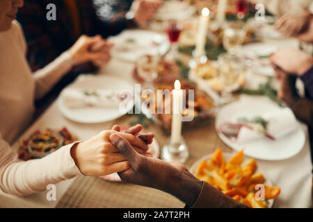 Nahaufnahme der Menschen am Esstisch auf Weihnachten und verbinden Hände im Gebet sitzen, Platz kopieren Stockfoto