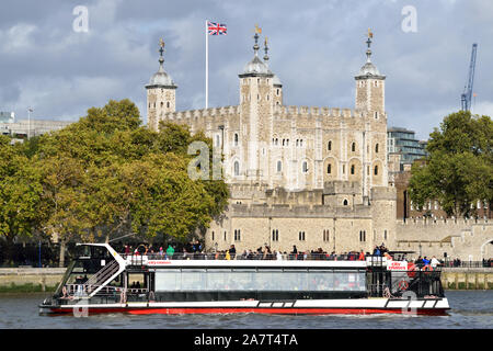 Eines der City Cruises London Sightseeing-Boote auf der Themse vorbei an den Tower of London Stockfoto