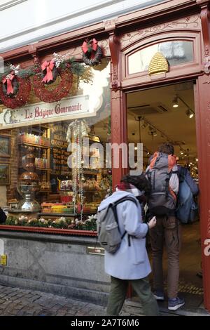 Rucksack Touristen Eingabe ein Schokoladengeschäft in Brügge, Belgien. Stockfoto