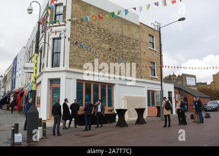 London, Großbritannien. 4. Okt 2019. Neu Banksy Kunstwerk 'Graffiti Maler' offenbart durch Royal Borough von Kensington und Chelsea Stellvertretender Bürgermeister Cllr Walaa Idris, und Enstar capital CEO Simon Lyons in London Notting Hill wiederhergestellt. Die banksy Artwork wiederhergestellt durch Enstar wird auf permanente Anzeige für die Gemeinschaft bleiben. An der Ecke der Ackam Straße und der Portobello Road, dem Stencil Artwork "Graffiti Maler' stellt Spanischen Barock Maler Diego Velasquez Gemälde "BANKSY" in roter Farbe auf einer weißen Giebelwand. Credit: thamesfleet/Alamy leben Nachrichten Stockfoto