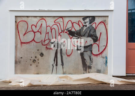 London, Großbritannien. 4. Okt 2019. Neu Banksy Kunstwerk 'Graffiti Maler' offenbart durch Royal Borough von Kensington und Chelsea Stellvertretender Bürgermeister Cllr Walaa Idris, und Enstar capital CEO Simon Lyons in London Notting Hill wiederhergestellt. Die banksy Artwork wiederhergestellt durch Enstar wird auf permanente Anzeige für die Gemeinschaft bleiben. An der Ecke der Ackam Straße und der Portobello Road, dem Stencil Artwork "Graffiti Maler' stellt Spanischen Barock Maler Diego Velasquez Gemälde "BANKSY" in roter Farbe auf einer weißen Giebelwand. Credit: thamesfleet/Alamy leben Nachrichten Stockfoto