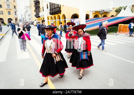 LIMA, PERU- circa OKTOBER 2019: Peruanische Damen in traditioneller ländlicher Kleidung, die über den Hauptplatz von Lima laufen Stockfoto